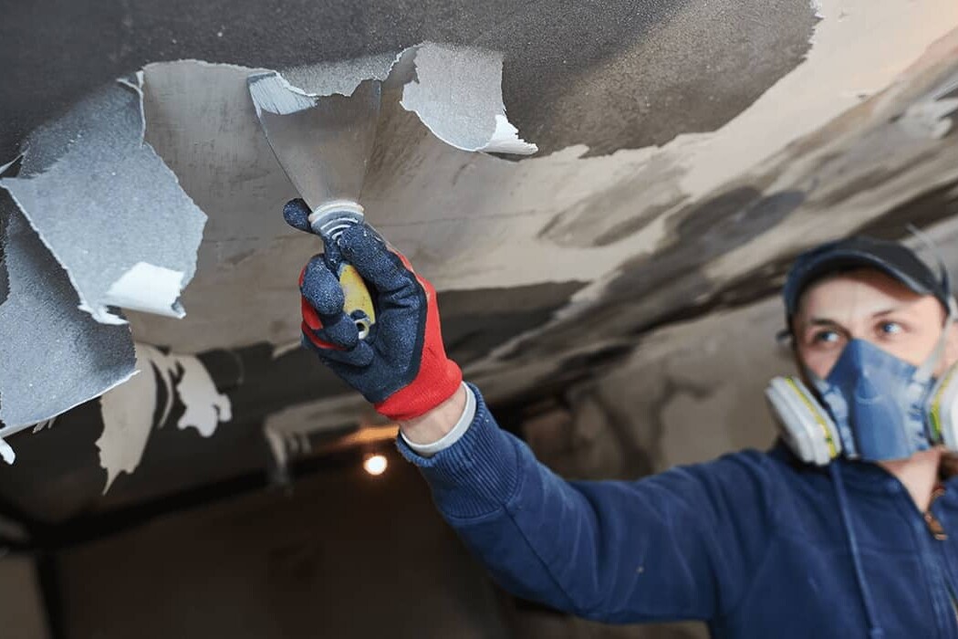 woman in oxygen mask scraping ceiling